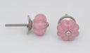 Roze keramieken meubelknop in de vorm van een bloem met metalen details.
