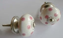 Decoratieve keramieken knop in een bolvorm met wit en roze polka dot patroon