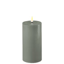 Saliegroene DeluxeHomeart LED kaars van 7,5 cm breed en 15 cm hoog.