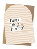 Jots wenskaart hiep hiep hoera A5 formaat met koperfolie details op een witte en zandkleurige achtergrond met kraft envelop.