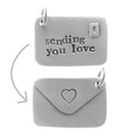 Grijze bedel in de vorm van een envelop met de tekst 'sending you love'