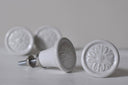 Witte keramische meubelknoppen met een taps toelopende vorm en metalen voet.