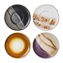 Set van vier ronde HKliving bordjes van keramiek met een multi kleur patroon.