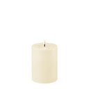 DeluxeHomeart LED kaars in creme kleur met een wasachtig oppervlak en een diameter van 7,5 cm en hoogte van 10 cm.