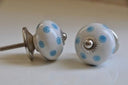 Ronde keramische knop met een lichtblauw polkadot-patroon op een witte ondergrond