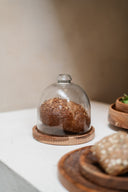 Glazen stolp op een rond houten onderbord van 15 cm diameter.