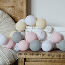 Cotton Ball Lights lichtslinger in de kleurcombinatie soft met grijze, zandkleurige, witte en mintkleurige ballen van polyester garen.