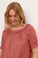 Cream blouse in de kleur redwood, gedragen in een casual stijl.