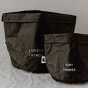 Twee zwarte papieren opbergzakken met de teksten lovely things en tiny things