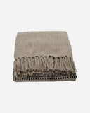 House Doctor plaid in zand en zwart met zichtbare structuur en decoratieve franjes