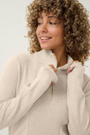 Dames Cream trui in de kleur creme met een hoge kraag en goudkleurige rits.