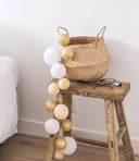Cotton Ball Lights lichtslinger in de uitvoering touch of gold met witte, gouden en schelpwitte bollen van polyester garen.